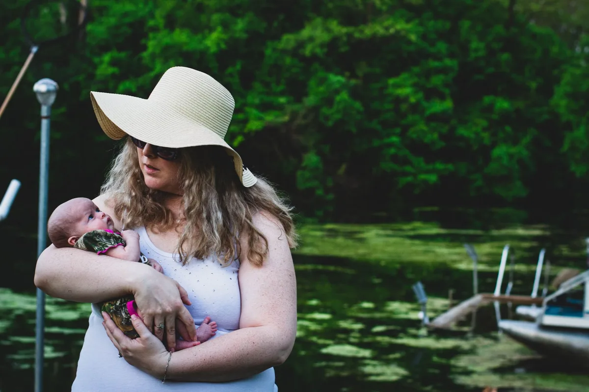 Bébé portant un chapeau à large bord assis à l'ombre en extérieur