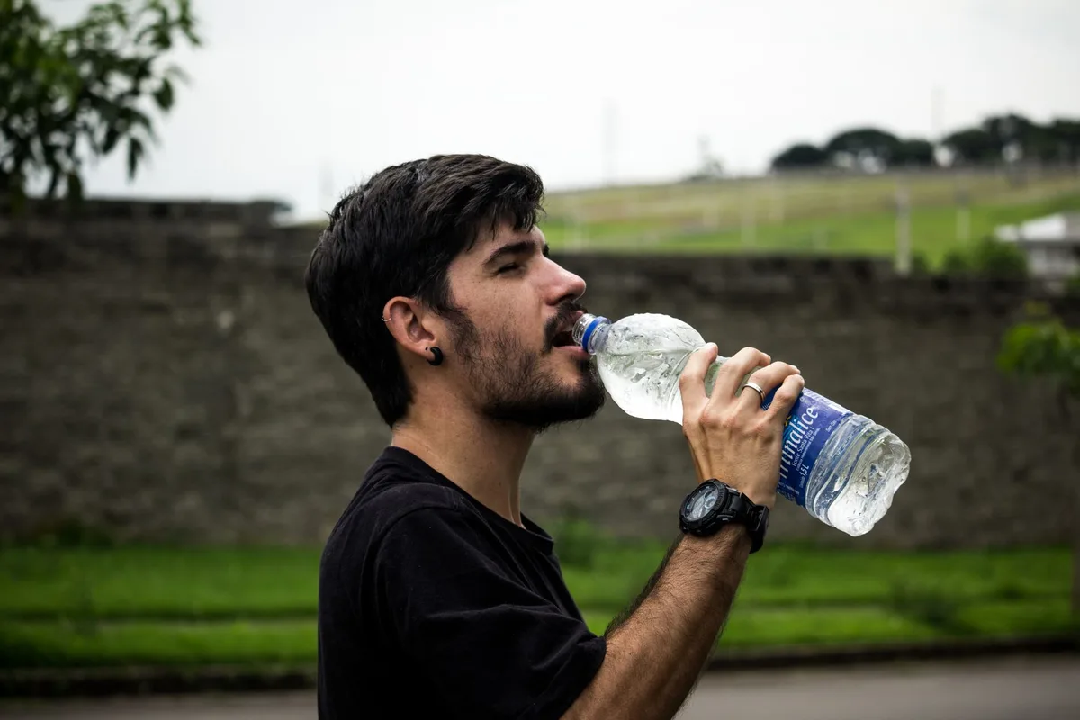 Bébé buvant de l'eau à la bouteille pour rester hydraté par temps chaud