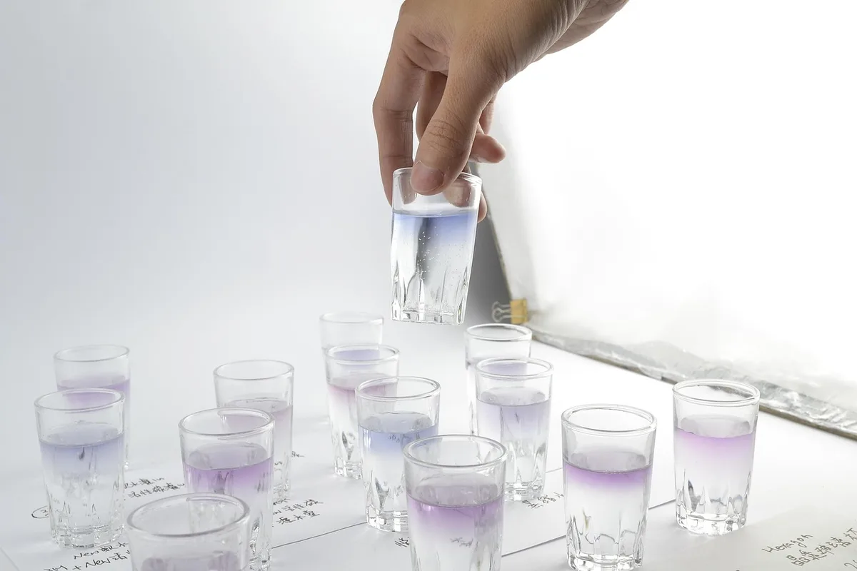 Prélèvement d'eau de rivière pour tests, montrant la contamination aquatique par résidus organiques
